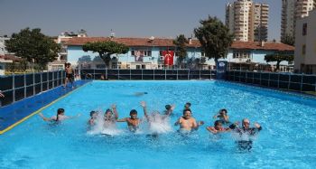 Mersin'de çocuklar okul bahçelerine kurulan portatif havuzlarda yüzme öğreniyor